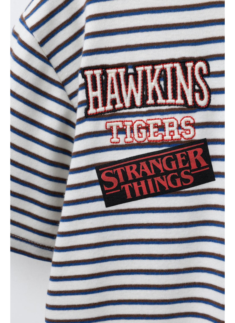 ФУТБОЛКА В ПОЛОСКУ STRANGER THINGS © NETFLIX ФУТБОЛКА В ПОЛОСКУ STRANGER THINGS © NETFLIX